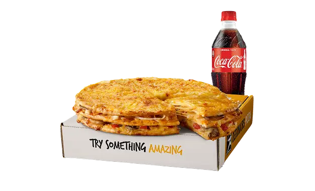Small triple decker on top of a takeaway box with a drink in the background