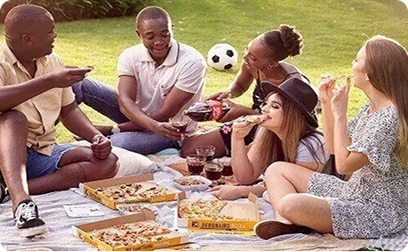 People sharing pizza in outside setting