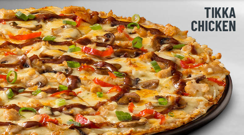 Tikka chicken pizza on a black slate