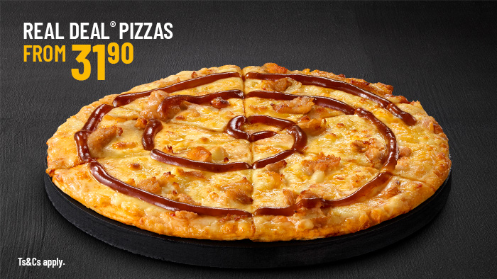 Real Deal Pizzas promotional banner featuring a sliced cheese and chicken pizza drizzled with barbecue sauce swirl.